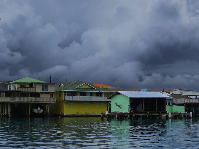 Storm clouds over waterside homes in Caribbean