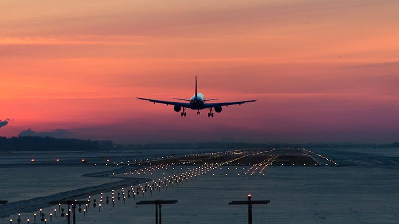 Airplane taking off at sunset
